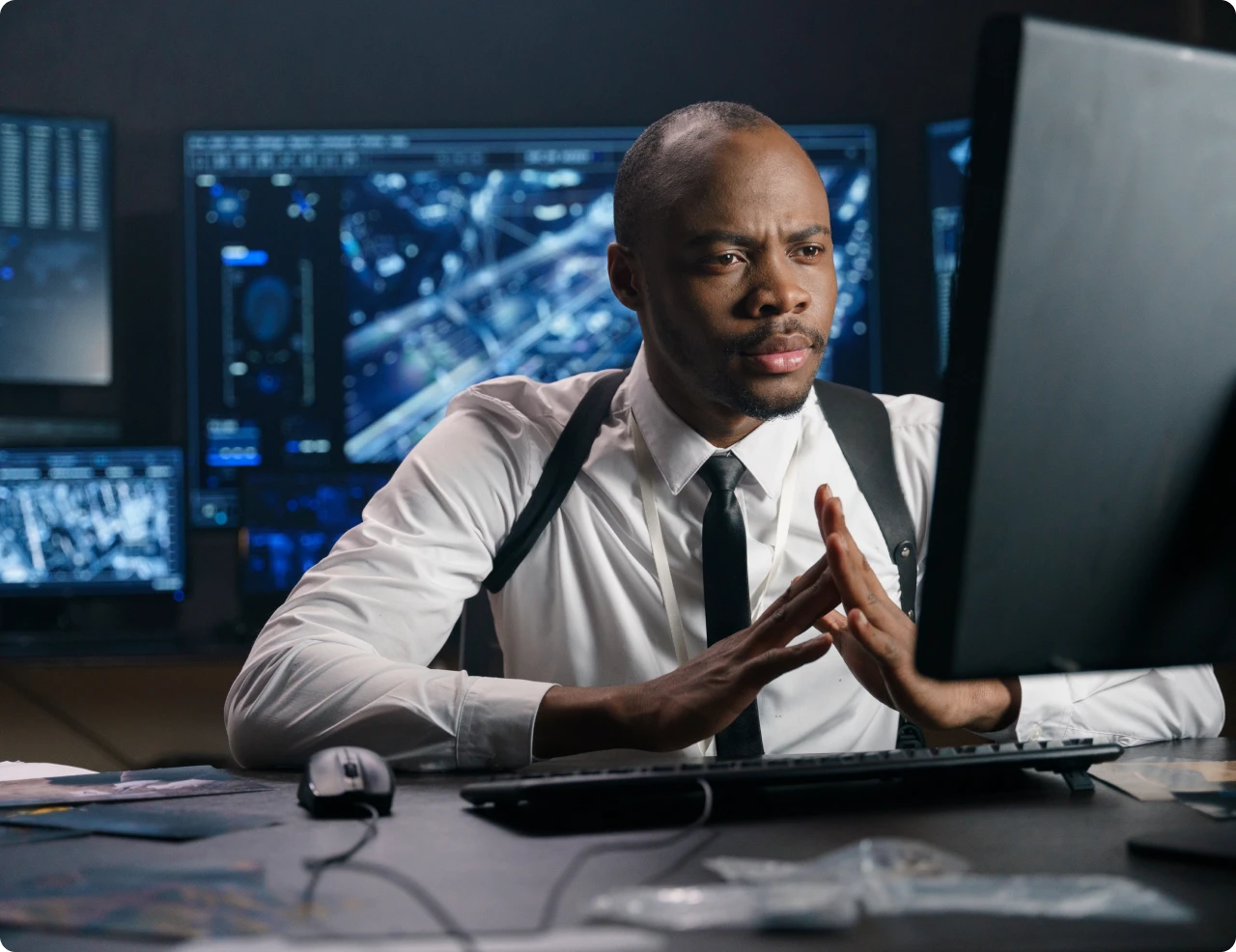 Man focused on computer screens in office.